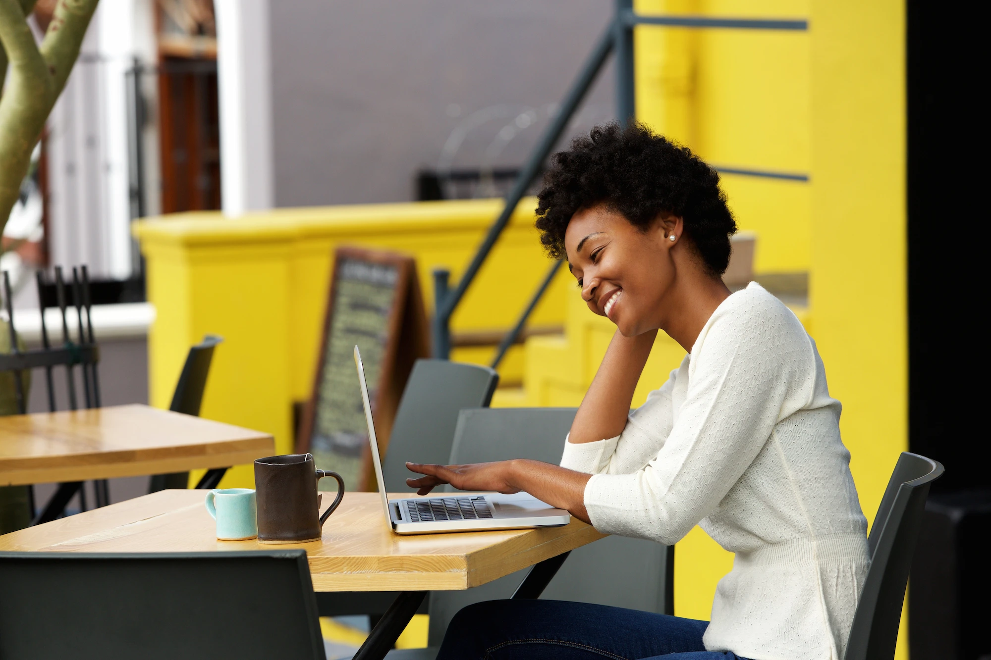 A woman sitting at a table using a computer.